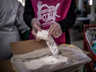 Des membres de l'association Les Restos du Cœur emballent des savons recyclés pour les bénéficiaires, le 24 mars 2021 à Givors - JEFF PACHOUD [AFP]
