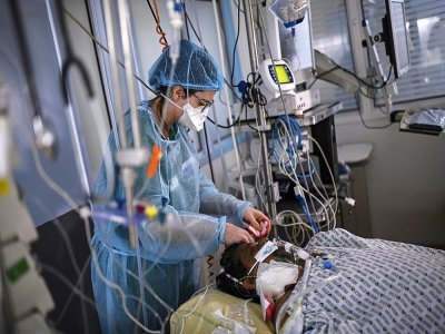 Une infirmière soigne un patient atteint du Covid-19, à l'hôpital Cochin de l'AP-HP à Paris, le 18 mars 2021 - Christophe ARCHAMBAULT [AFP/Archives]