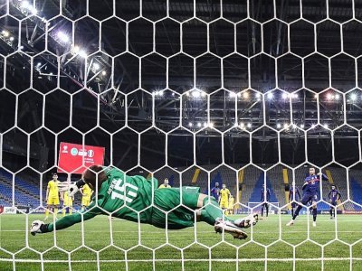 Le gardien de but du Kazakhstan, Aleksandr Mokin, détourne le pénalty tiré par l'attaquant français Kylian Mbappé (R), lors du match de qualification au Mondial-2022, le 28 mars 2021 à Noursoultan - FRANCK FIFE [AFP]