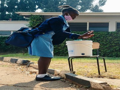 Une jeune fille se désinfecte les mains avant d'entrer à l'école le 28 septembre 2020 à Harare (Zimbabwe) - Jekesai NJIKIZANA [AFP/Archives]