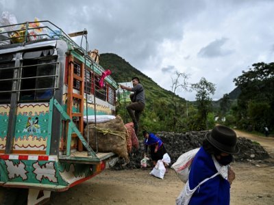 Des sacs de nourriture sont déchargés d'une "chiva" à Silvia, en Colombie, le 9 mars 2021 - Luis ROBAYO [AFP]