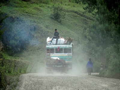 Une "chiva" chargée de passagers et de sacs de nourriture sur une route rurale de Silvia, en Colombie, le 9 mars 2021 - Luis ROBAYO [AFP]
