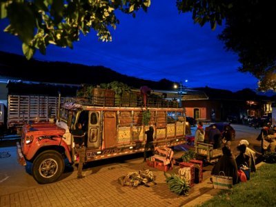 Des sacs de nourriture sont déchargés d'une "chiva", à Silvia, en Colombie, le 9 mars 2021 - Luis ROBAYO [AFP]