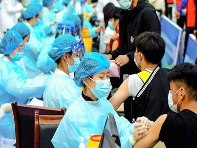 Une soignante administre une dose du vaccin Sinovac contre le Covid-19 dans une université de Qingdao en Chine, le 30 mars 2021 - STR, STR [AFP]