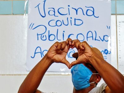 Un sans-abri fait un coeur avec ses mains pour remercier d'avoir été vacciné contre le Covid-19 dans le cadre d'une campagne de vaccination destinée aux sans-domicile-fixe dans les rues de Sao Paulo, au Brésil, le 30 mars 2021 - Miguel SCHINCARIOL [AFP]