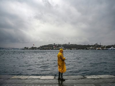 Un homme pêche sur la rive du détroit du Bosphore au port de Karakoy à Istanbul, le 19 mars 2021. - Ozan KOSE [AFP]