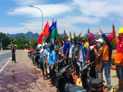 Photo diffusée par Eindu Youths le 6 avril 2021 montrant des manifestants faisant le salut à trois doigts et déversant de la peinture rouge sur une route à Hpa-an, capitale de l'Etat Karen, dans le sud de la Birmanie - Handout [Eindu Youths/AFP]