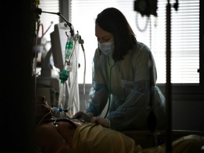 Une soignante s'occupe d'un patient infecté par le Covid-19 qui se trouve en soins intensifs à l'hôpital européen Georges-Pompidou à Paris, le 6 avril 2021 - Anne-Christine POUJOULAT [AFP]