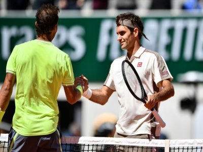 L'Espagnol Rafael Nadal (g.) et le Suisse Roger Federer (d.) se serrent la main à la fin de leur match de demi-finale du simple messieurs lors de la 13e journée du tournoi de tennis Roland Garros 2019 à Paris, le 7 juin 2019. - Martin BUREAU [AFP]