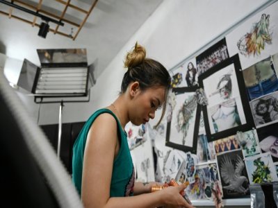 Ngoc Like dans son studio de tatouage, le 20 mars 2021 à Hanoï, au Vietnam - Manan VATSYAYANA [AFP]