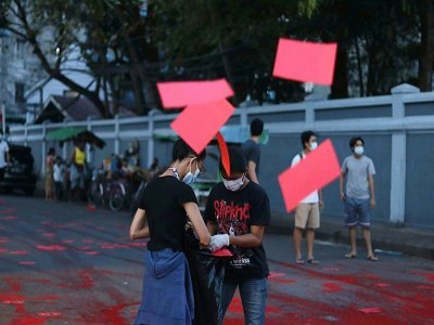 Photo provenant de Facebook et d'une source anonyme de manifestants déversant de la peinture rouge et distribuant des flyers à Rangoun, le 10 avril 2021 pour dénoncer le coup d'état militaire - Handout [FACEBOOK/AFP]