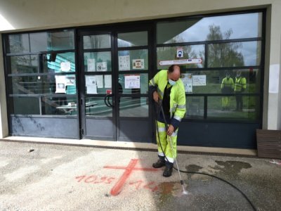 Un employé municipal nettoie des tags anti-musulmans devant le centre culturel islamique Avicenne, le 11 avril 2021 à Rennes - JEAN-FRANCOIS MONIER [AFP]