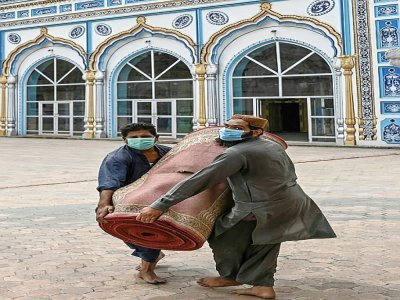 Des fidèles musulmans transportent un tapis dans une mosquée de Rawalpindi (Pakistan) le 5 avril 2021 - Aamir QURESHI [AFP]
