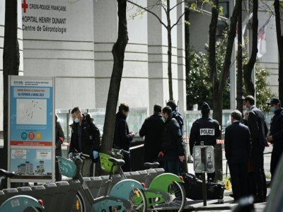Des policiers devant l'hôpital Henry Dunant où une personne a été tuée et une autre blessée par balles, le 12 avril 2021 à Paris - Anne-Christine POUJOULAT [AFP]