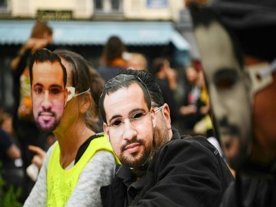 Des manifestants portant des masques à l'effigie d'Alexandre Benalla sont rassemblés le 1er mai 2019 sur la place de la Contrescarpe à Paris - Anne-Christine POUJOULAT [AFP/Archives]