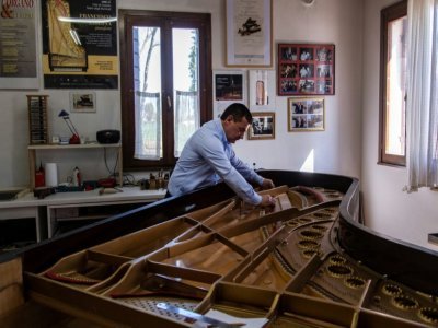 Le facteur de pianos italien Luigi Borgato travaille sur une nouvelle création dans son atelier à Borgo Veneto, le 8 avril 2021 en Italie - MARCO BERTORELLO [AFP]