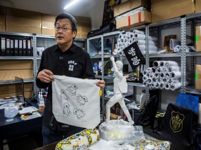 Herbert Chow montre un sac en tissu de la marque Chickeeduck, le 9 avril 2021 à Hong Kong - ISAAC LAWRENCE [AFP]
