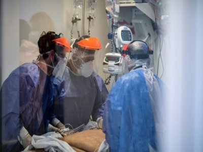 Des infirmiers autour d'un patient atteint du Covid-19 en soins intensifs à l'hôpital El Cruce, à Florencio Varela, dans la banlieue de Buenos Aires le 13 avril 2021 - RONALDO SCHEMIDT [AFP]