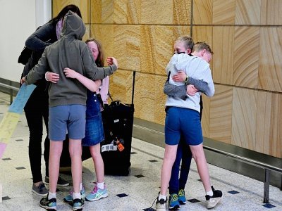 Une famille en provenance deNouvelle-Zélande retrouve ses proches à son arrivée à Sydney le 19 avril 2021 - SAEED KHAN [AFP]