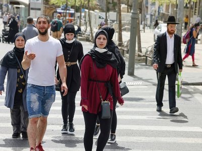 Des passants marchent sans masque dans une rue de Jerusalem le 18 avril 2021 - menahem kahana [AFP]
