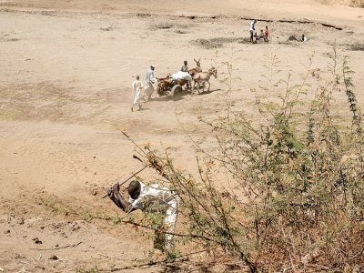 Des villageois traversent la rivière asséchée de Rahad près du parc national de Dinder au Soudan, le 9 avril 2021 - ABDULMONAM EASSA [AFP]