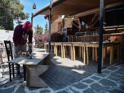 Un employé prépare la réouverture d'un café-restaurant à Thessalonique (Grèce), le 22 avril 2021 - Sakis MITROLIDIS [AFP]