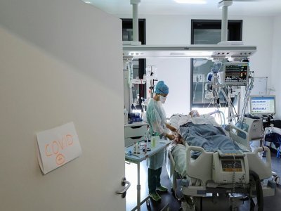 Une soignante s'occupe d'un patient atteint du Covid-19 dans l'unité de soins intensifs à l'hôpital Pasteur de Colmar, le 22 avril 2021 - SEBASTIEN BOZON [AFP]