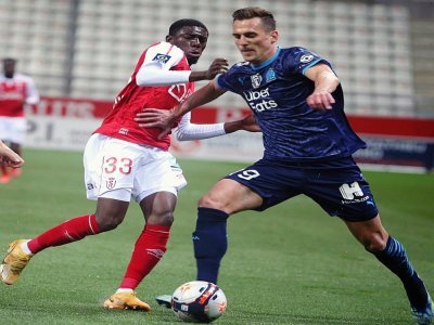 L'attaquant polonais de Marseille, Arkadiusz Milik, tente de dribbler le défenseur malien de Reims, Fodé Doucouré, lors de leur match de L1, le 23 avril 2021 au stade Auguste Delaune - FRANCOIS NASCIMBENI [AFP]