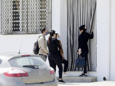 Des journalistes parlent à une cousine (d) du Tunisien Jamel Gorchene devant la maison familiale de Msaken, dans le nord-est de la Tunisie, le 24 avril 2021 - FETHI BELAID [AFP]