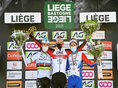 Le vainqueur de Liège-Bastogne-Liège, le Slovène Tadej Pogacar (c), encadré par les Français Julian Alaphilippe (g), 2e, et David Gaudu, 3e, sur le podium, le 25 avril 2021 - ERIC LALMAND [Belga/AFP]