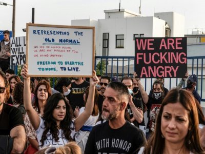 Des manifestants sans masques de protection protestent devant le siège de la police de Nicosie contre de nouvelles restrictions sanitaires sévères imposées pour parer à la pandémie de Covid-19, le 25 avril 2021 - Iakovos Hatzistavrou [AFP]