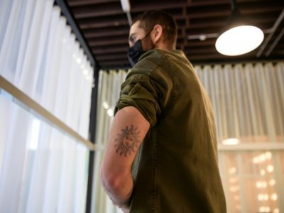 Josh Sakhai, l'un des co-fondateurs d'Ephemeral, montre l'un des tatouages éphémères qu'il s'est fait faire sur lui-même, le 21 avril 2021 - Angela Weiss [AFP]