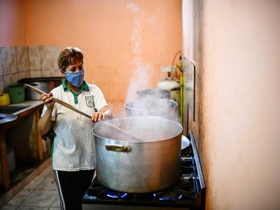 Une femme cuisinant dans une soupe populaire du quartier Puerta de Hierro, à La Matanza, banlieue pauvre de Buenos Aires, le 12 avril 2021 - Ronaldo SCHEMIDT [AFP]