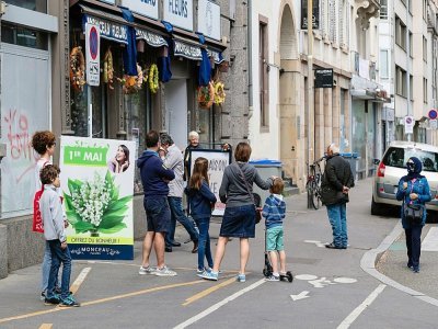 Des clients attendent devant un magasin de fleurs pour acheter du muguet, le 1er mai 2020 à Strasbourg - PATRICK HERTZOG [AFP]