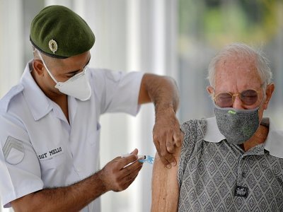 Un militaire vaccine un homme âgé contre le Covid-19 à Belo Horizonte, le 1er mai 2021 au Brésil - Douglas MAGNO [AFP]
