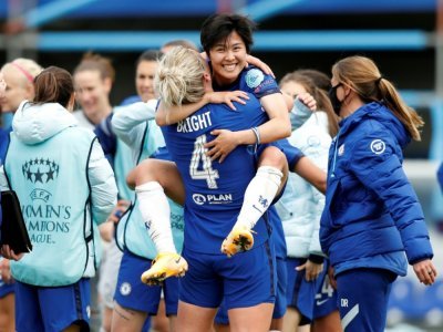 La milieue de terrain sud-coréenne de Chelsea Ji So-yun saute dans les bras de la défenseuse Millie Bright après la victoire de Chelsea 4 à 1 contre le Bayern Munich en demi-finale retour de la Ligue des champions féminines à Londres le 2 mai 2021. - Adrian DENNIS [AFP]