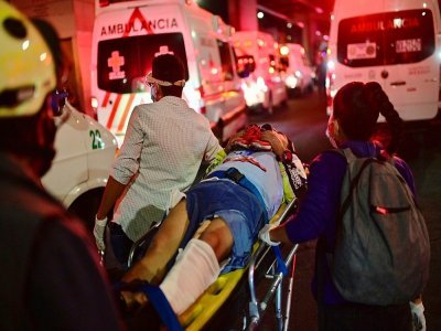 Des ambulanciers évacuent un blessé après l'effondrement d'un pont du métro aérien au passage d'une rame, le 3 mai 2021 à Mexico - Pedro PARDO [AFP]