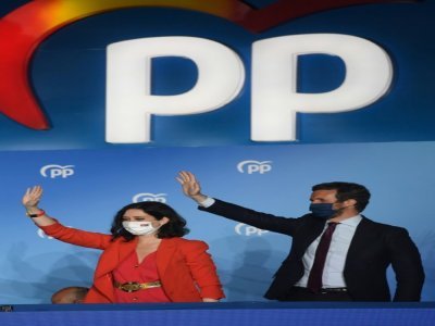 La candidate à la présidence de la région de Madrid, Isabel Diaz Ayuso (g) et le dirigeant du Parti populaire (PP), Pablo Casado, saluent leurs partisans après la victoire de leur parti aux élections régionales, le 4 mai 2021, à Madrid - PIERRE-PHILIPPE MARCOU [AFP]