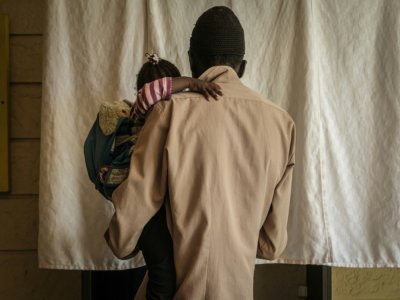 Un patient dépendant de l'héroïne avec sa fille âgée de 2 ans attend un traitement de substitution, dans une clinique de MSF à Karuri, au Kenya, le 29 janvier 2021 - Yasuyoshi CHIBA [AFP]