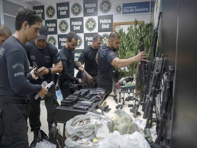 Des policiers rangent les drogues et armes saisies à la suite d'une opération antidrogue dans la favela de Jacarezinho à Rio de Janeiro le 6 mai 2021. - MAURO PIMENTEL [AFP]