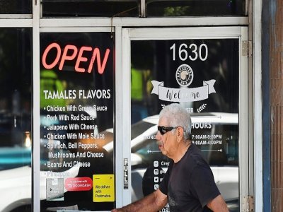 Un homme passe devant un restaurant ouvert de Los Angeles en Californie le 5 mai 2021 - Frederic J. BROWN [AFP]
