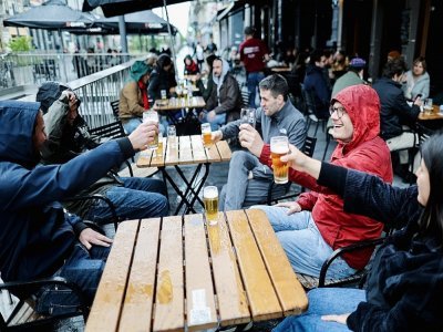 Des clients à la terrasse d'un café, le jour de la réouverture des bars et restaurants, le 8 mai 2021 à Bruxelles - Kenzo TRIBOUILLARD [AFP]