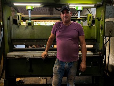 Le carrossier Pedro Manso devant une machine qu'il a lui-même fabriquée pour reproduire les pièces d'origine des vieilles voitures américaines, le 24 avril 2021 dans son atelier de Placetas, dans la province de Villa Clara, à Cuba - ADALBERTO ROQUE [AFP]