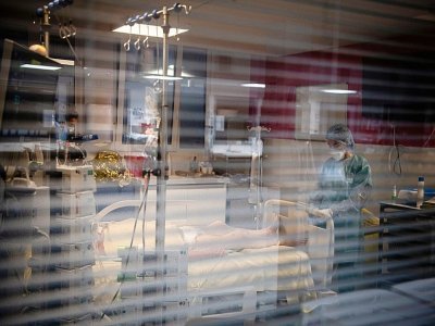 Une soignante s'occupe d'un patient atteint du Covid-19 dans une unité de soins intensifs de l'hôpital Louis Mourier, le 4 mai 2021 à Colombes, près de Paris - ALAIN JOCARD [AFP/Archives]