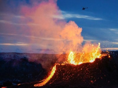 Un hélicoptère survole une coulée de lave en fusion  près du mont Fagradalsfjall, à une quarantaine de kilomètres de Reykjavik, le 6 avril 2021 en Islande - Halldor KOLBEINS [AFP/Archives]