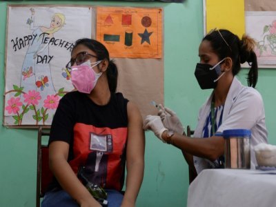 Un soignant administre une dose de vaccin à une femme dans un centre de vaccinations de New York, le 11 mai 2021 - Arun SANKAR [AFP]