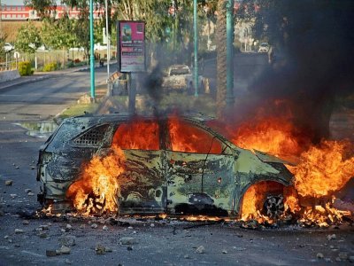Un véhicule de la police israélienne brûle après une manifestation d'Arabes Israéliens à Lod (Israël), le 11 mai 2021 - - [AFP]