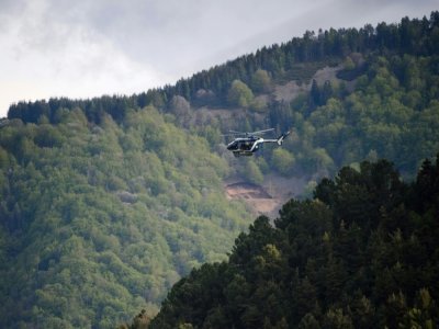 Un hélicoptère survole une zone forestière des Cévennes, le 12 mai 2021, à la recherche du fugitif qui a tué deux personnes - CLEMENT MAHOUDEAU [AFP]