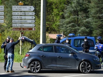 Un gendarme contrôle le coffre d'une voiture aux Plantiers, le 12 mai 2021, à la recherche du fugitif qui a tué deux personnes - Sylvain THOMAS [AFP]