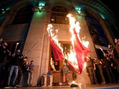 Des hommes mettent feu à un drapeau turc et un drapeau de l'Azerbaïdjan à Erevan, en Arménie, le 23 avril 2021 - Karen MINASYAN [AFP]